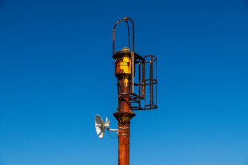 Rusty communication tower under blue sky near Syracuse
