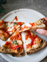 Delicious pizza slices on a plate with melted cheese and fresh toppings, food concept. copy space