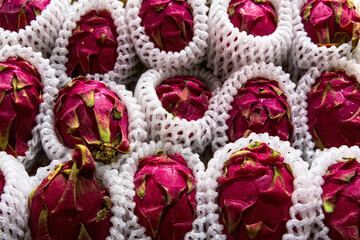 Fresh raw pink dragon fruits close up in full box top view in supermarket.