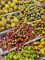 Colorful display of exotic tropical fruits arranged in rows at a local market.