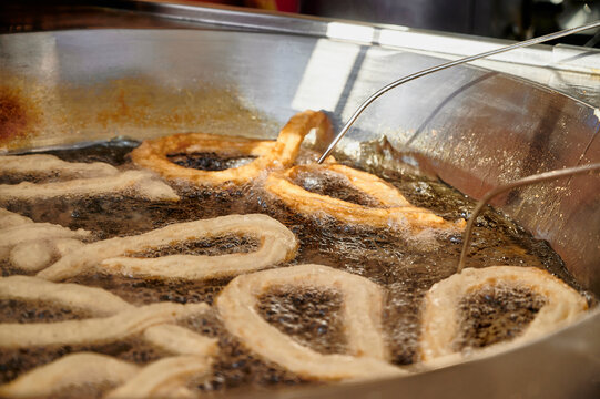 Close up of metal rods used for flipping porras (big churro) while frying in boiling oil inside a professional fryer. Essential equipment in traditional Spanish churrer&iacute;as