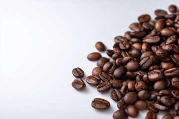 Roasted coffee beans scattered on a white background. Rich, dark brown tones.