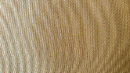 Background of reflective brown yarn woven fabric, gold gradient thick denim texture, shiny reflective beige fabric.
