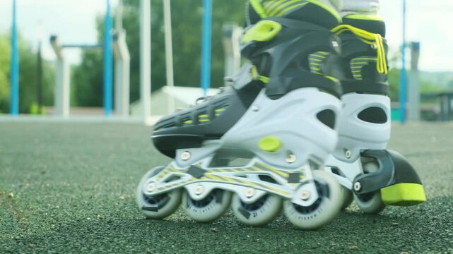 Close up roller blades. Roller skating girl kid in park rollerblading on inline skates.