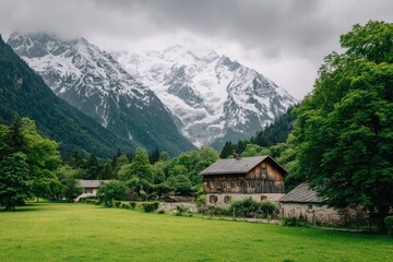 Alpine village nestled in a valley, snow-capped mountains loom in the background. Lush green landscape