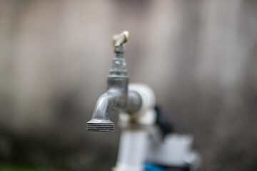 Metal water tap with soft focus background