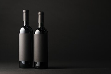 Bottles of wine on black background, space for text