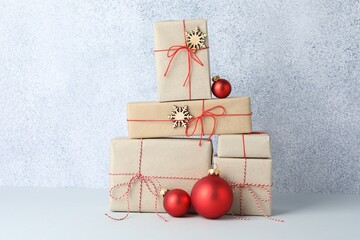 Many gift boxes wrapped in kraft paper and Christmas decor on light table