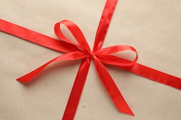 Gift wrapped in kraft paper and bow as background, top view