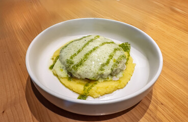 Hearty Schnitzel with Mashed Potatoes, Creamy White Sauce, and Pesto Drizzle.Close-up: Savory Schnitzel, Mashed Potatoes, Rich Cream Sauce, Green Herb Garnish
