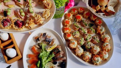 Elegant catering service displaying gourmet canapes and appetizers arranged on white plates, preparing for upscale event or celebratory gathering