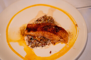 Seared fish fillet served over wild rice at formal dinner