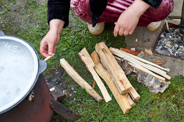 Tajik woman lighting a fire for the kazan to cook pilaf