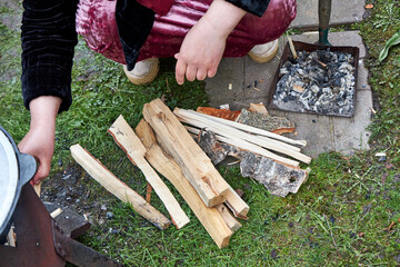 Tajik woman lighting a fire for the kazan to cook pilaf