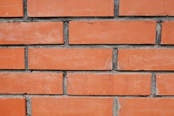 Clean red brick wall with straight lines and visible cement joints. Ideal for use as a construction background, architectural texture, or building material detail.