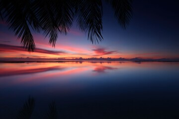 Beautiful sunset over tranquil waters with silhouettes of palm trees