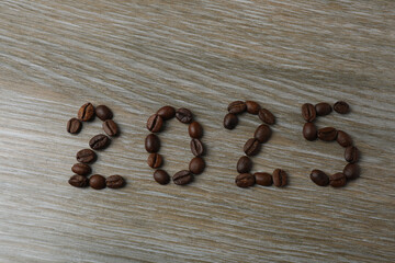 Hot coffee in a white coffee cup and many coffee beans scattered around 