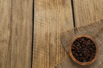 Hot coffee in a white coffee cup and many coffee beans scattered around 