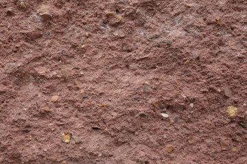 Extreme close-up of a rough textured concrete surface with embedded gravel and stone particles. High detail background for architectural, industrial, or construction design use.