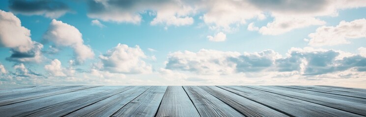 A serene view of a blue sky filled with fluffy clouds, overlooking a wooden plank boardwalk. This tranquil image captures a peaceful outdoor atmosphere perfect for various themes.