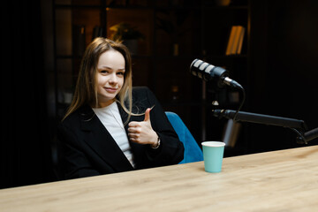 Radio host gesturing thumbs up during a podcast recording