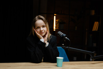 Confident female podcaster recording a new episode in her studio