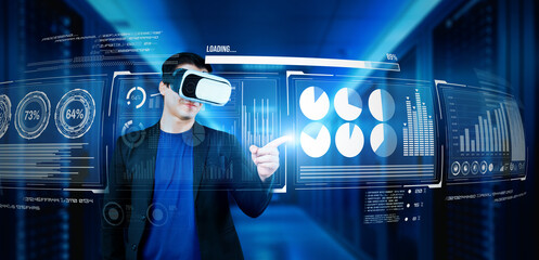 Businessman with headset standing at data center while analyzing financial data. Manager pointing marketing statistic hologram and using augmented reality goggles while making a decision. Ingenuity.