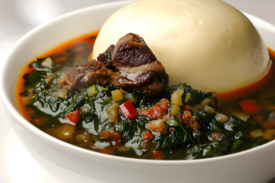 A neatly arranged bowl of fufu and egusi soup with tender meat, showcasing a traditional West African meal