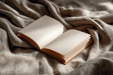 Hardcover blank book on a linen fabric surface, soft daylight, cozy home setting