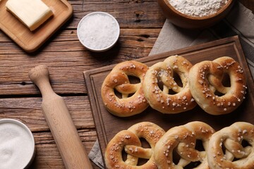 Tasty pretzels and ingredients on wooden table, flat lay