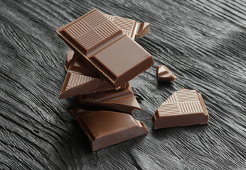 Broken dark chocolate on a wooden table