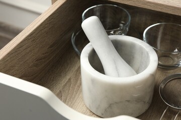 Marble mortar and pestle in drawer indoors, closeup