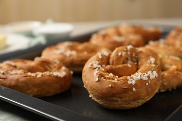 Tasty pretzels with salt on table, closeup