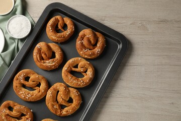 Tasty pretzels and ingredients on wooden table, flat lay. Space for text