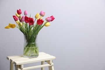 Bouquet of beautiful tulips on table indoors. Space for text