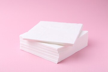 Stack of white handkerchiefs on pink background, closeup