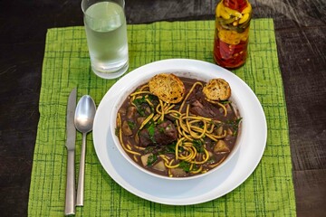 Traditional black bean soup with noodles and pork ribs, rustic Brazilian food known as sopa preta or sopa de benzedeira