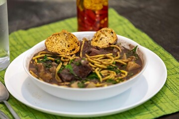 Traditional black bean soup with noodles and pork ribs, rustic Brazilian food known as sopa preta or sopa de benzedeira