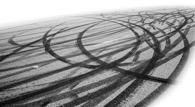 Fototapeta Tire tracks on asphalt surface showing skid marks and circular patterns in a monochrome photograph