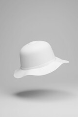 Fototapeta premium A white bowler hat on a gray backdrop.