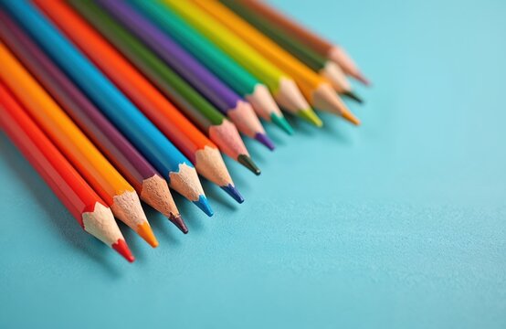 Arrangement of sharp colored pencils for creativity, drawing. Bunch of colorful pencils on blue background. Pencils art background, school equipment, drawing tools, creative design. School, office