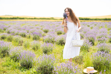 beautiful girl in a dress on a lavender field with a bouquet of flowers