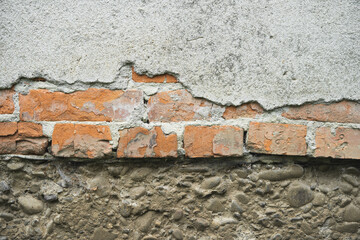 texture of old cracked brick wall and peeling plaster