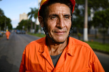 Gari – smiling street cleaner in Brazil wearing orange uniform