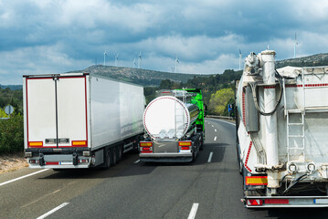 Multiple truck overtake, using the third lane to pass—a lane prohibited for trucks, rear view.