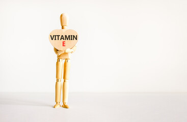 Vitamin E tocopherols symbol. Concept words Vitamin E on beautiful wooden heart. Doctor's model. Beautiful white background. Copy space. Medical healthy lifestyle Vitamin E tocopherols concept.