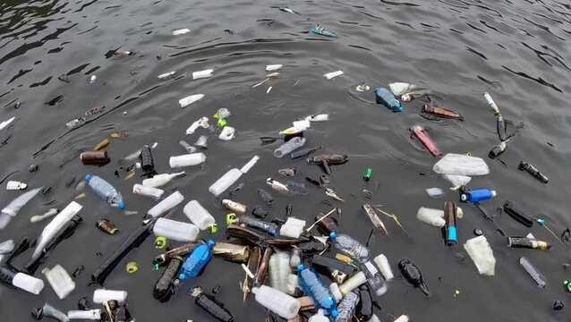 Floating plastic bottles and trash in ocean water, concept of marine pollution and environmental degradation