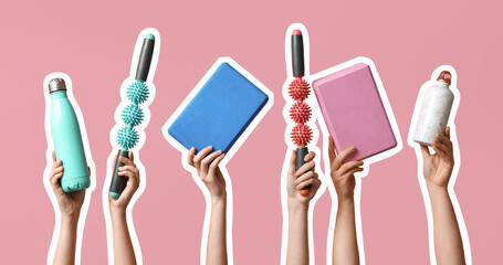 Female hands with yoga blocks, sports water bottles and roller massager sticks on pink background