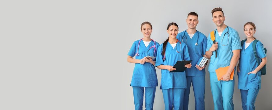 Group of medical students on grey background with space for text