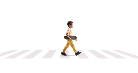 Full length profile shot of a boy walking at zebra crossing and carrying a skateboard